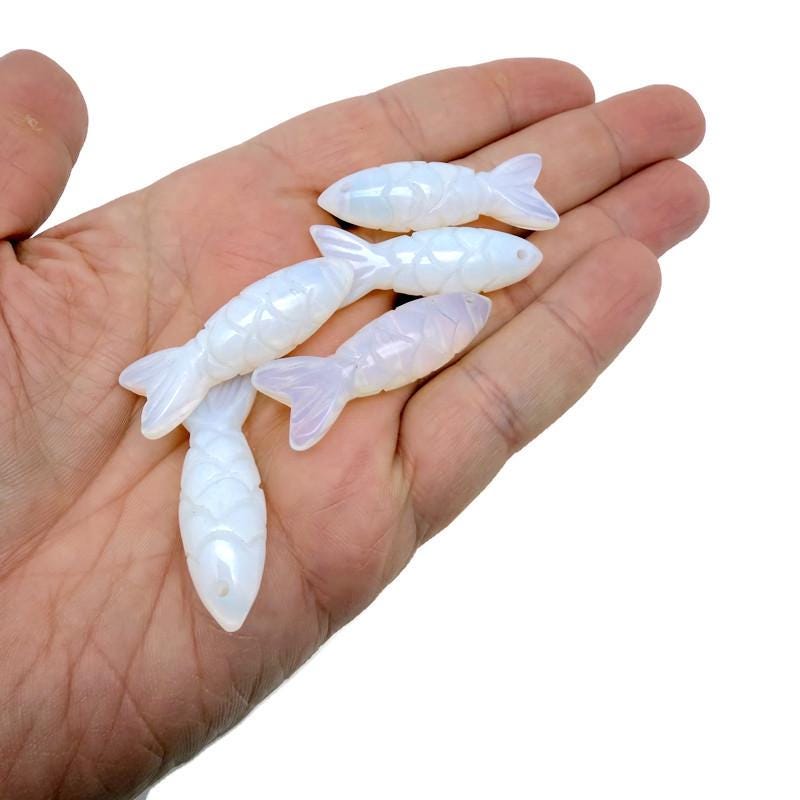 Opalite fish-shaped gemstone pendant with a silver bail, featuring a shiny, smooth surface ideal for jewelry or lucky charm.