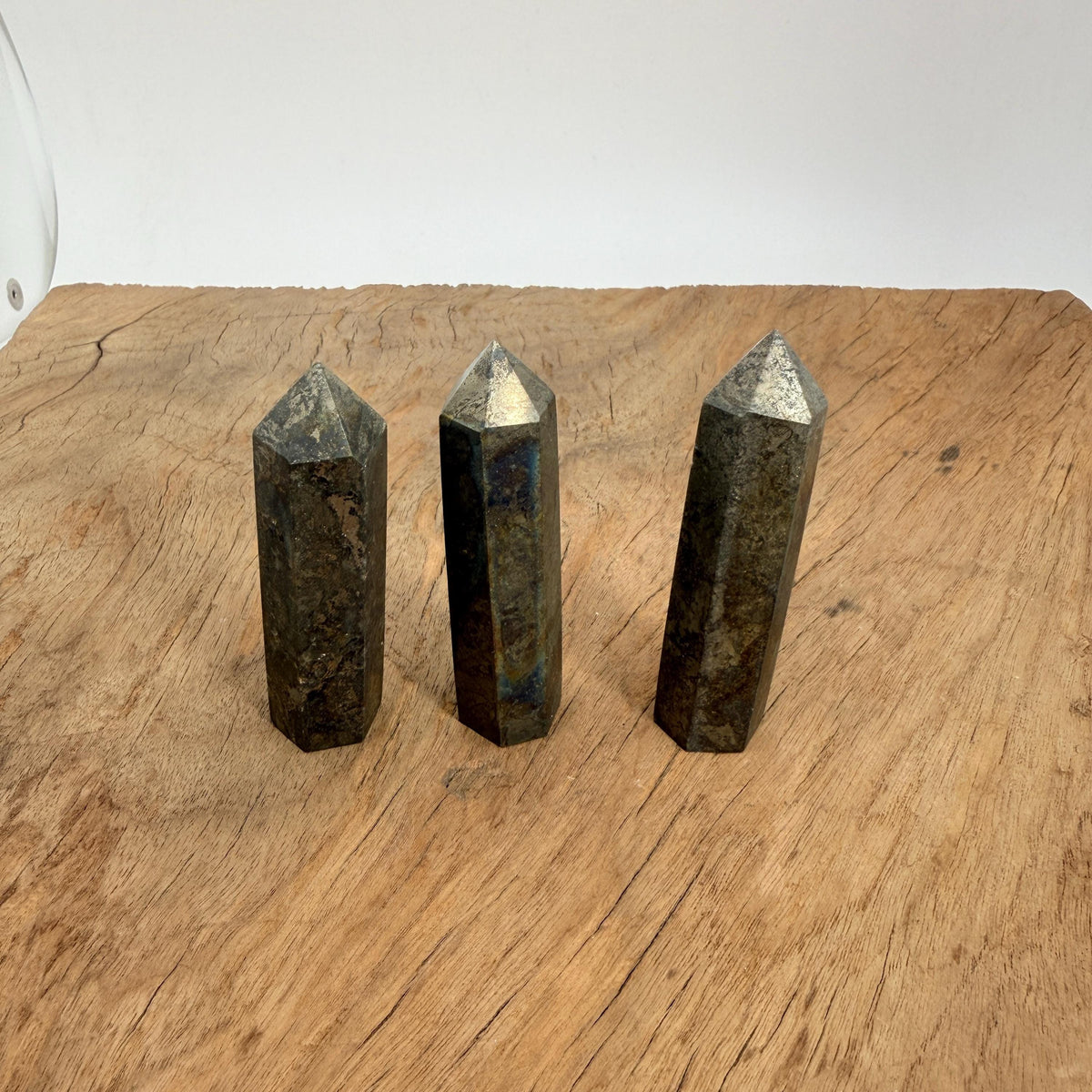 Pyrite obelisk tower crystal from GemstoneGO, showing its metallic gold sheen and natural crystal formation on a plain background.