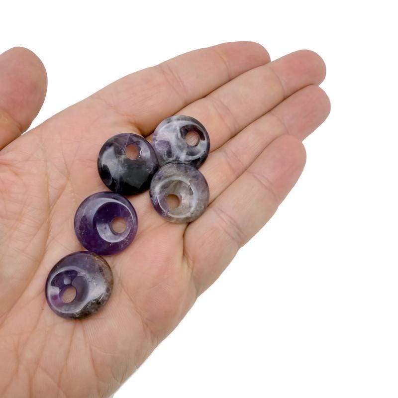 Amethyst crystal donut pendant from GemstoneGO, 20mm Pi stone with purple hues and polished smooth surface.