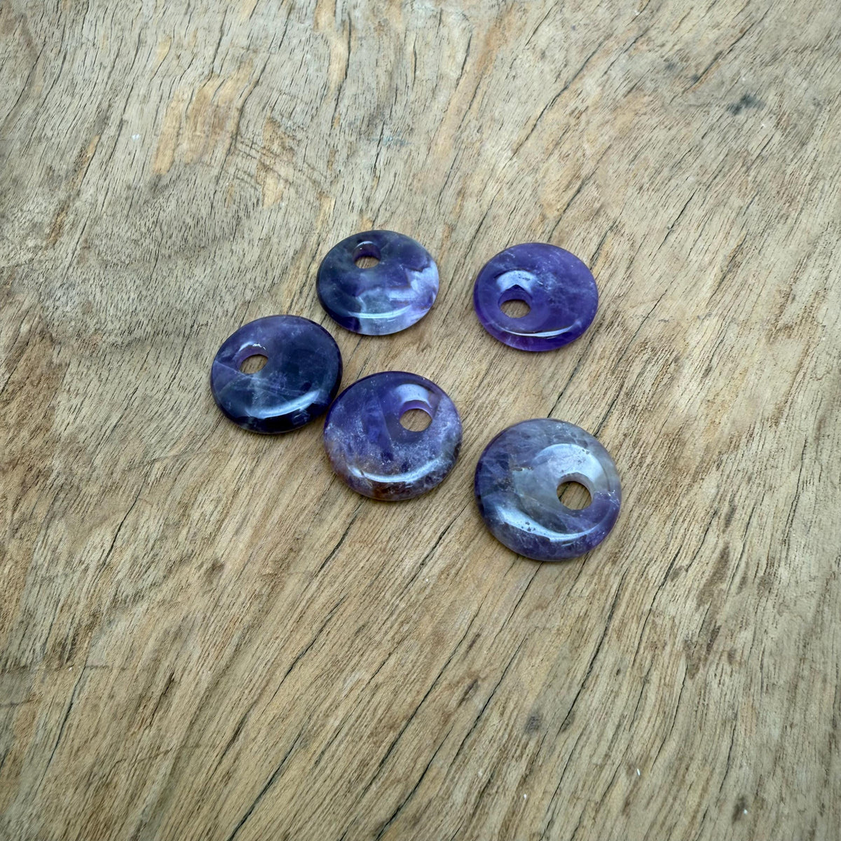 Amethyst crystal donut pendant from GemstoneGO, 20mm Pi stone with purple amethyst gemstone and polished smooth surface.