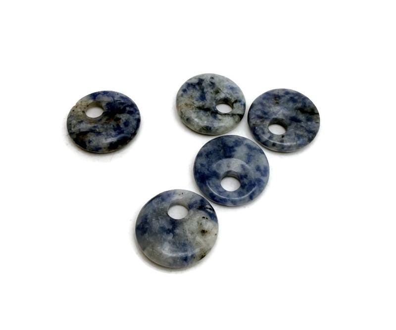 Sodalite crystal donut pendant, 20mm Pi stone from GemstoneGO, featuring deep blue and white mineral patterns on a polished surface.
