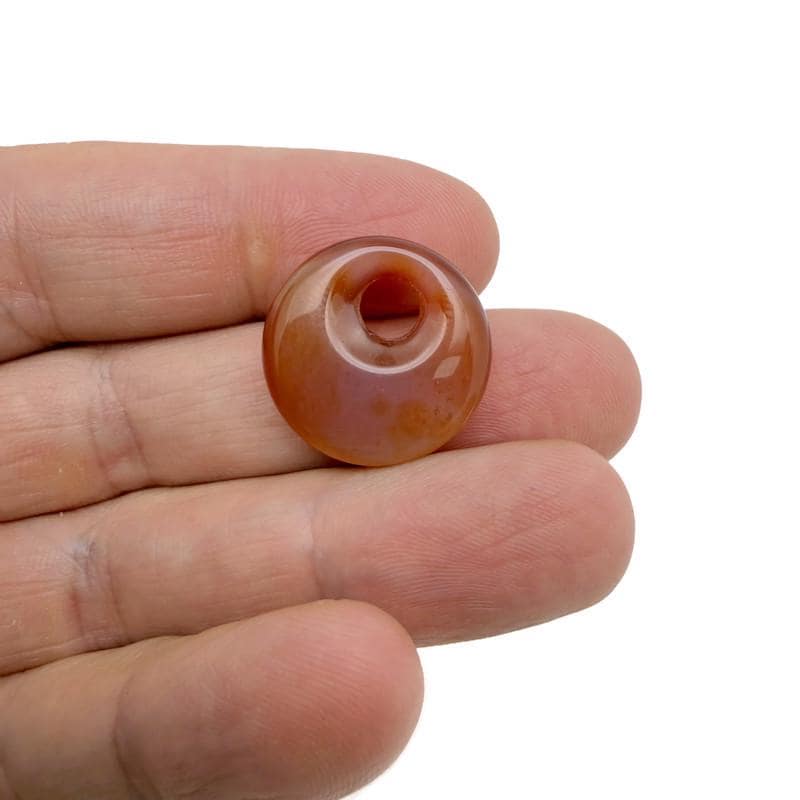 Pink carnelian crystal donut pendant from GemstoneGO, 20mm Pi stone with a smooth polished surface.