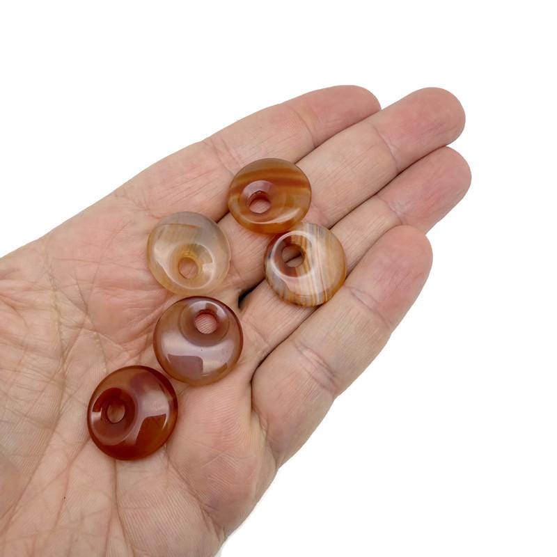 Carnelian crystal donut pendant from GemstoneGO, 20mm Pi Stone with vibrant orange-red hue and polished finish.