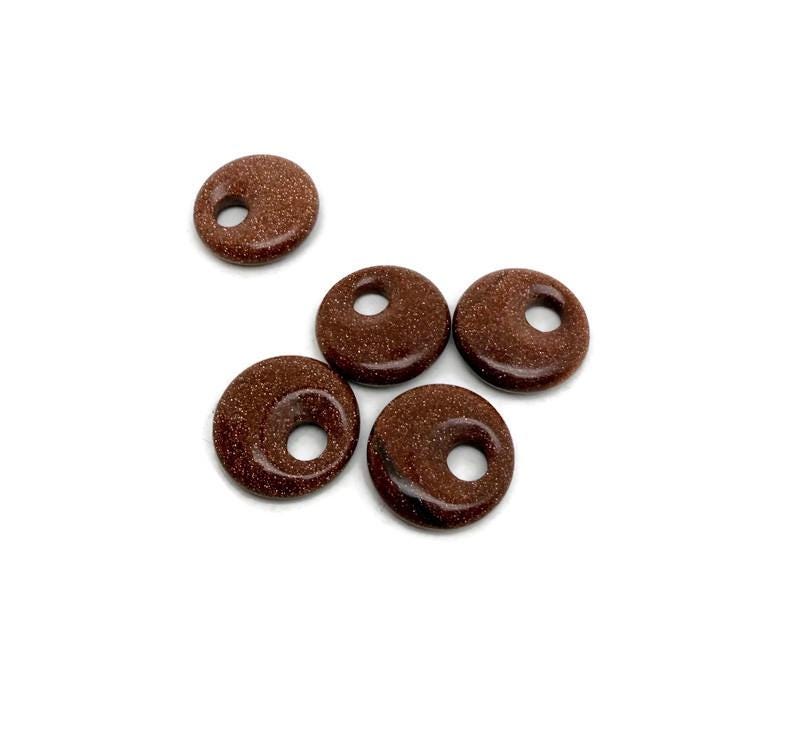 Goldstone crystal donut pendant, 20mm Pi stone from GemstoneGO, featuring a polished, rounded design with a shimmering goldstone surface.