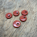 Red Jasper crystal donut pendant, 20mm Pi Stone by GemstoneGO, featuring a polished red jasper stone with natural patterns and a smooth surface.