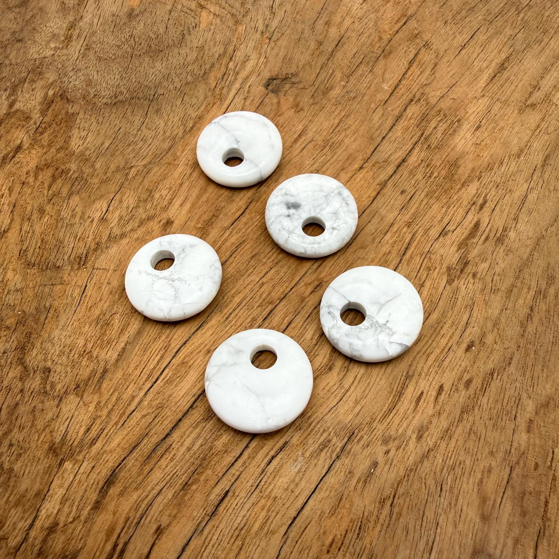 Howlite crystal donut pendant, 20mm Pi stone from GemstoneGO, showcasing smooth white and gray marbled gemstone with a hole in the center.