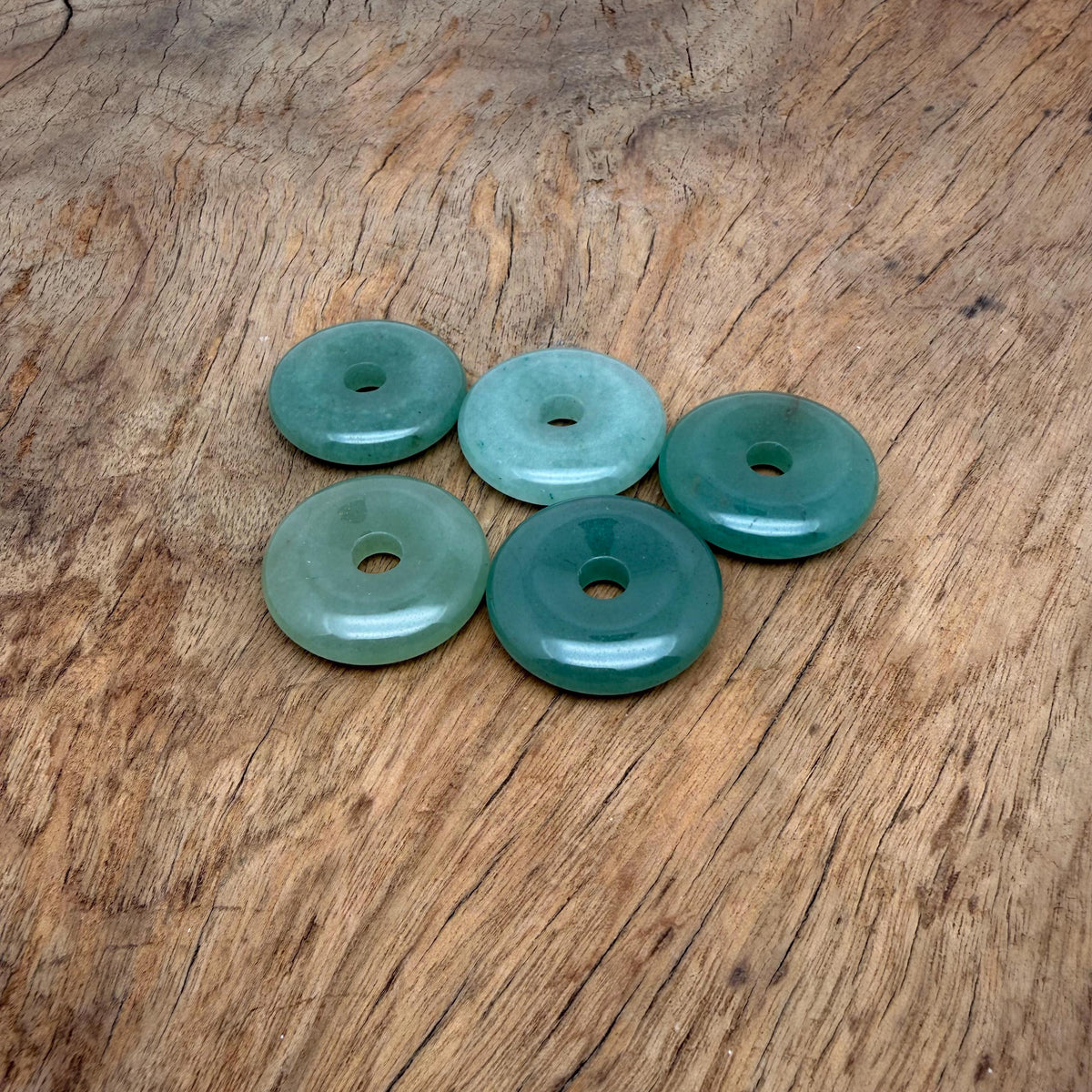 A 30mm aventurine crystal donut gemstone from GemstoneGO, showcasing its green, polished, donut-shaped design with natural stone patterns.