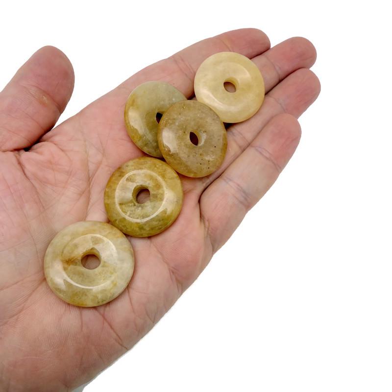Yellow jade crystal donut pendant from GemstoneGO, 30mm Pi stone with smooth, polished surface and vibrant yellow color.
