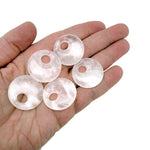 Clear quartz crystal donut pendant from GemstoneGO, 30mm Pi stone with polished, translucent appearance and smooth rounded edges.