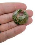 Unakite crystal donut gemstone from GemstoneGO, 30mm Pi stone with pink and green hues, polished and smooth surface.