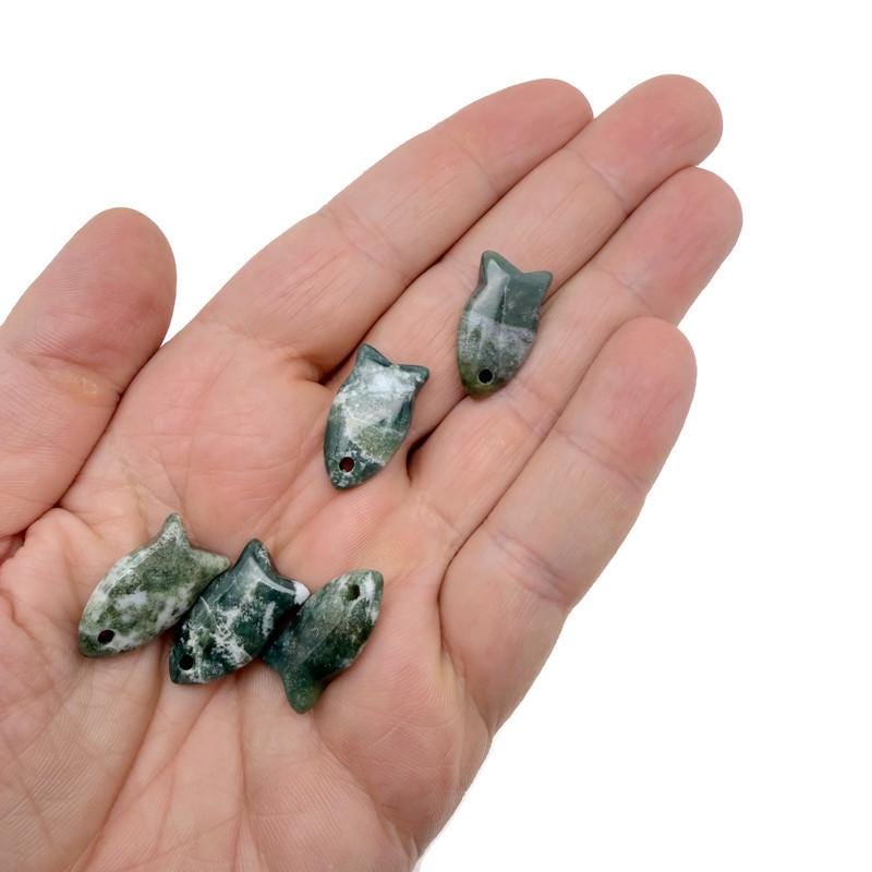 Moss agate fish-shaped crystal pendant with natural green and brown patterns, designed for jewelry and healing stones.