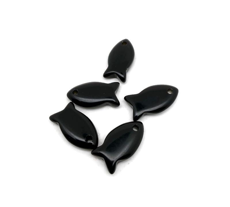 Obsidian fish-shaped crystal pendant with healing stone charm, crafted for jewelry, featuring a glossy black fish design.