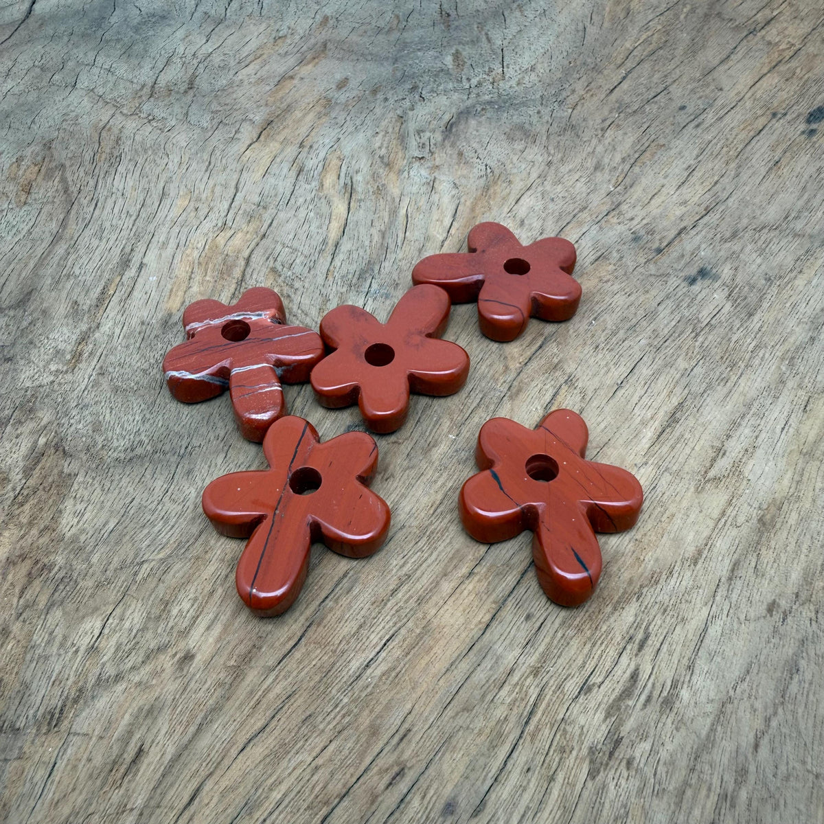 Red Jasper gemstone pendant featuring a carved crystal flower charm, showcasing a vibrant red floral design from GemstoneGO.