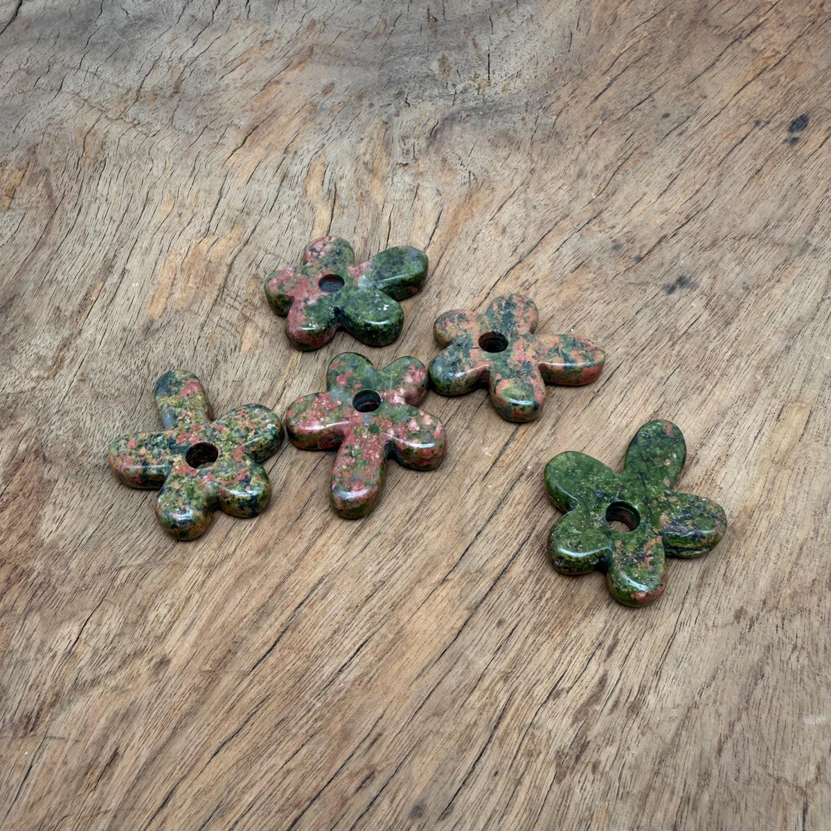 Unakite flower gemstone pendant featuring a carved crystal flower charm, showcasing vibrant colors and detailed craftsmanship.