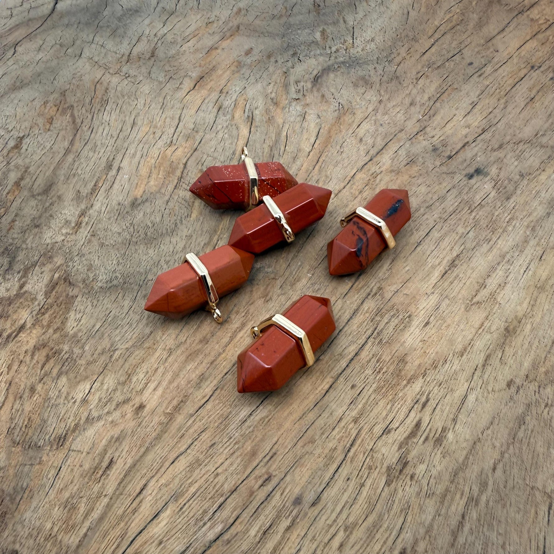 Red Jasper double terminated crystal pendant featuring a natural gemstone point with vibrant red color and unique natural markings.